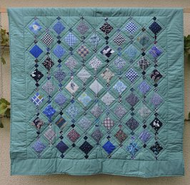Salbei: ruhiges Grün mit kontrastierenden blauen Mustern kann gut als Kniedecke genutzt werden.  Maße: 156x156cm Preis: € 280.- 