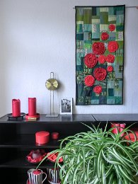 Rosenbeet - auf einem grünen Soffgemisch aus  Baumwoll- und Kunstfaserstoffen strahlen unterschiedlich große rotblühende Rosen.  Maße: 103x52cm Preis: € 120.- 