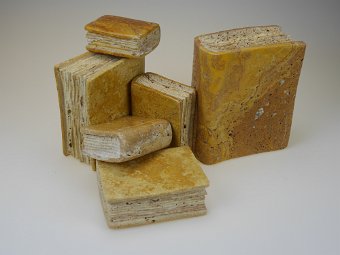 Travertin ist ein Süßwasserkalkstein, gebildet aus Kalkablagerungen. Charakteristisch sind die prägnanten Farbverläufe und die poröse Struktur, oft auch mit Calciteinschlüssen. Für meine Bücher verwende ich den gelben Cannstatter Travertin und den roten Persischen Travertin